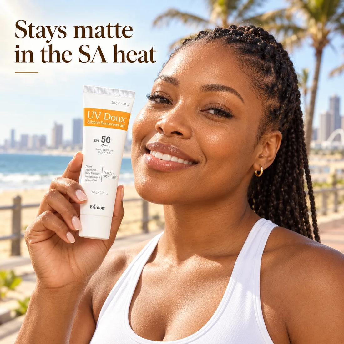 Smiling woman holding UV Doux Silicone Sunscreen Gel on a sunny Durban beachfront promenade